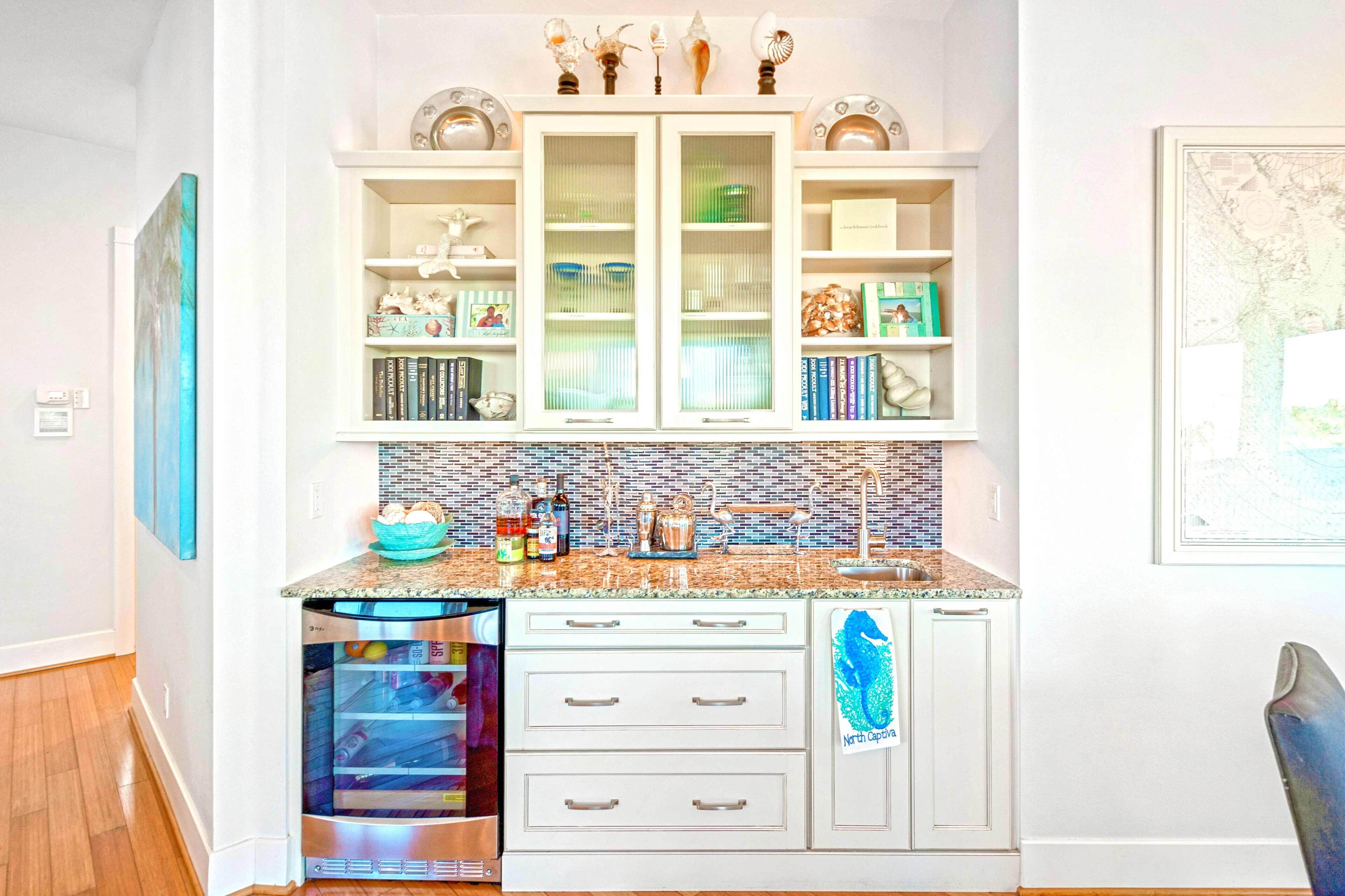 A kitchen with white cabinetry, a tiled backsplash, and a built-in dishwasher.