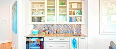 A kitchen with white cabinetry, a tiled backsplash, and a built-in dishwasher.