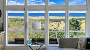 A room with a large window overlooking a beach and ocean.