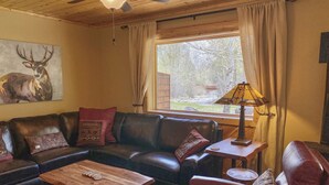 A cozy living room with a leather sofa, a wooden coffee table, and a lamp.