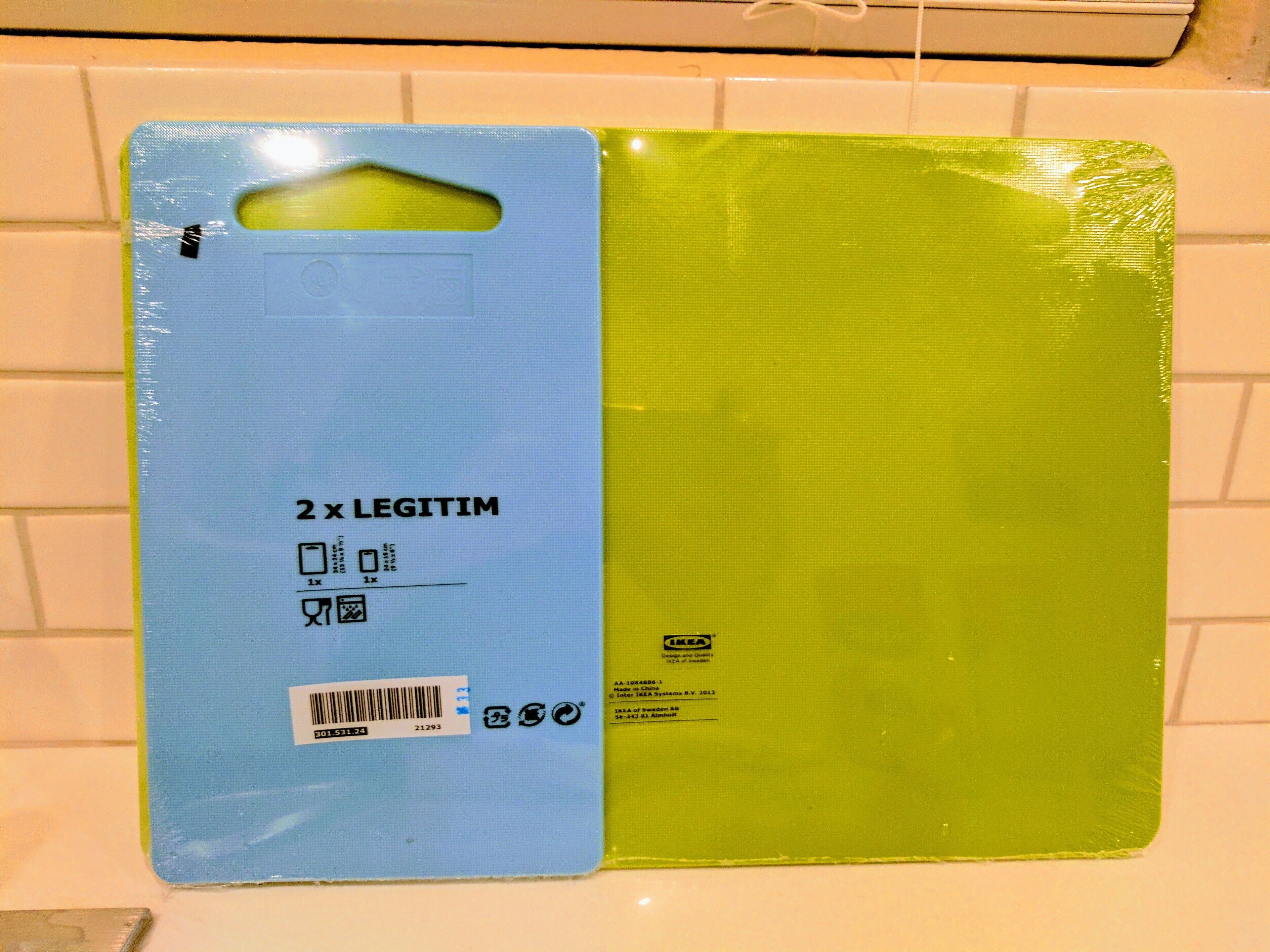 A blue and green plastic package with text and symbols indicating it is a product from IKEA.