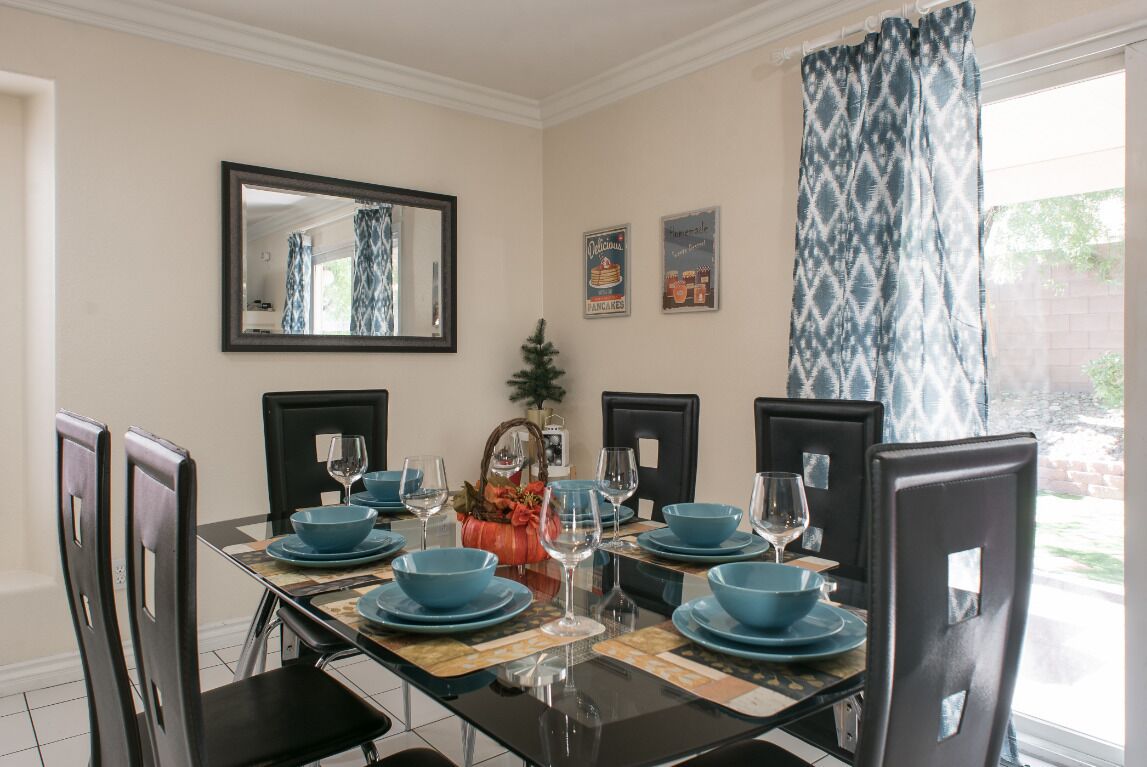 Een eetkamer met een rechthoekige tafel voor zes personen, omringd door zwarte stoelen.