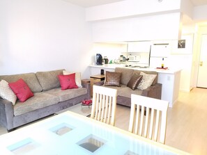 Relax in this stylish living area with a sofa, dining table, and kitchenette.