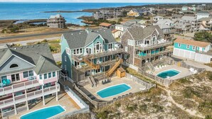 A coastal residential area with multiple houses featuring balconies and swimming pools.