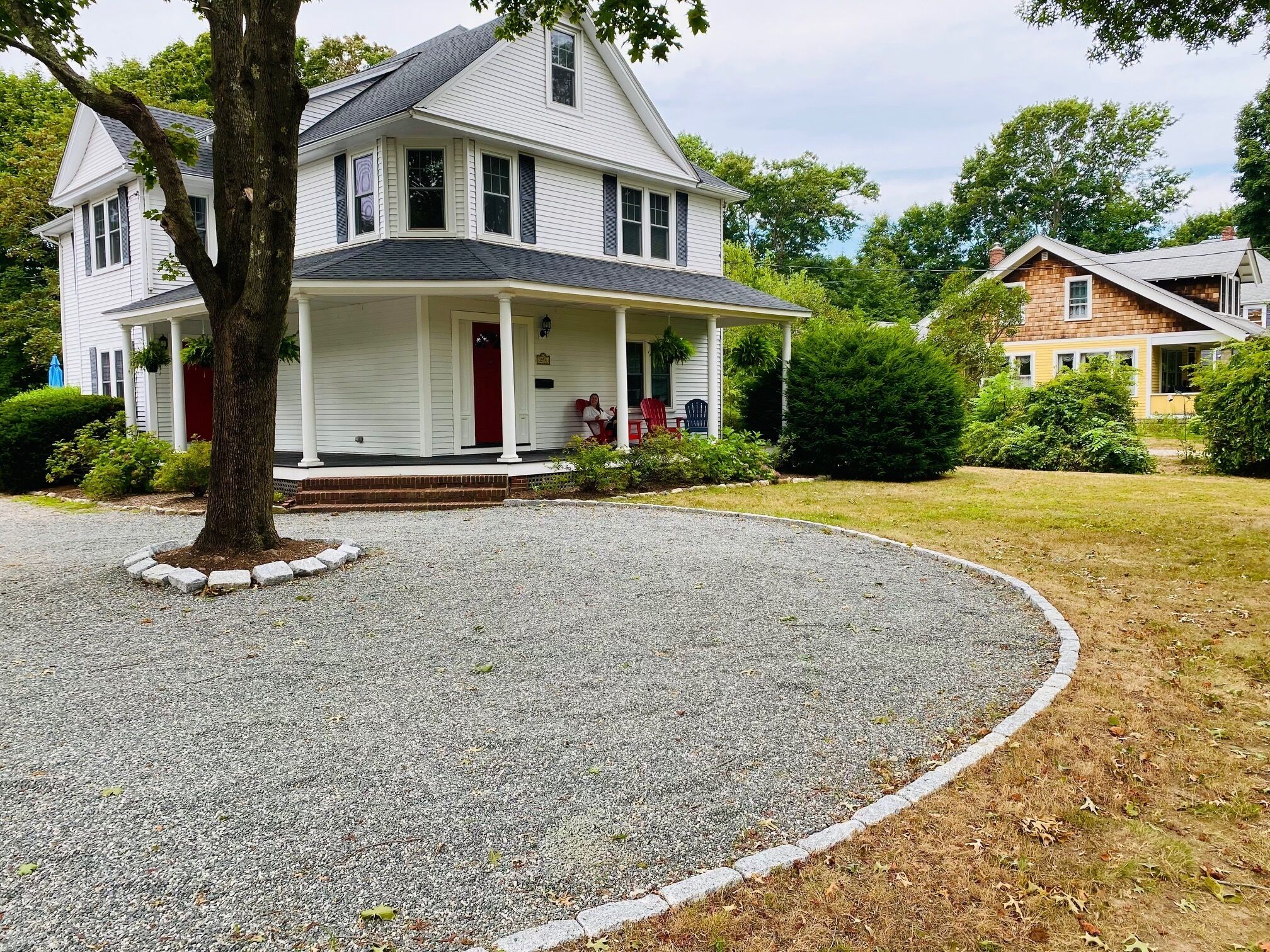 A two-story house with a front porch, a driveway, and a well-maintained lawn.