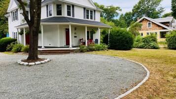 A two-story house with a front porch, a driveway, and a well-maintained lawn.