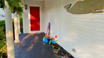 Steps lead to a welcoming entrance with a decorative wall feature and a cozy seating area.