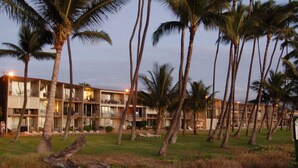 Un hotel de varios pisos, con palmeras y zonas de estar al aire libre.