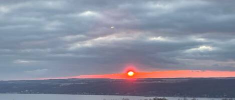 A sunset over a lake with a cloudy sky.