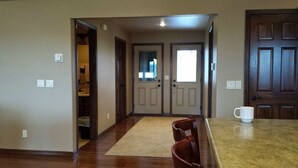 A spacious entryway with a wooden floor, a beige rug, and a dining area with a coffee table and chairs. - Calico Rock Cabin-406 Calico St 302 Chessmond Ferry Rd viewing the White River (Calico Rock)