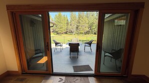 Puerta corrediza de vidrio que da a un patio exterior con mesa y sillas.