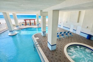 A pool area with a view of the beach, lounge chairs, and a hot tub. - Beachfront Majestic Condo - Pools, Views & Resort Fun, 6th floor convenience  (Panama City Beach)