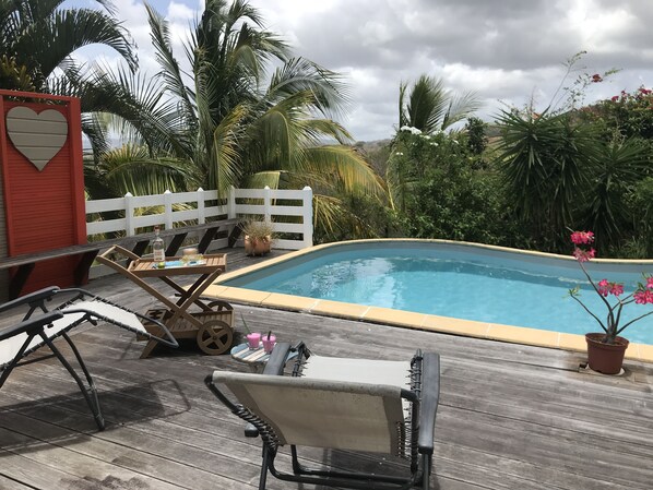 A wooden deck with a pool, lounge chairs, and a white fence. - 3-bedrooms apartment, modern, big pool, great sea view, 10 mn from beaches. (Les Trois-Îlets)