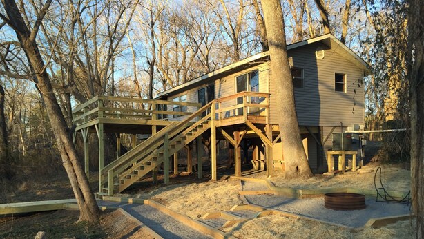 Une cabane en bois dotée d’une terrasse et d’un escalier menant à un balcon situé à l’étage.