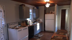 Une cuisine de taille réduite équipée d’une cuisinière, d’un four, d’un réfrigérateur et d’un évier.