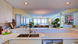 A spacious kitchen with a central island, a built-in dishwasher, and a view to a balcony. - Wind Drift 603SE
Gulf Front
RECENT CANCELATION!!!
BOOK NOW! (Orange Beach)