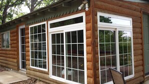 Eine Blockhütte mit großen Fenstern und einer Veranda.
