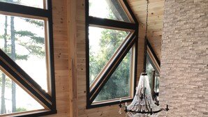A spacious loft with large windows, a chandelier, and a cozy seating area.