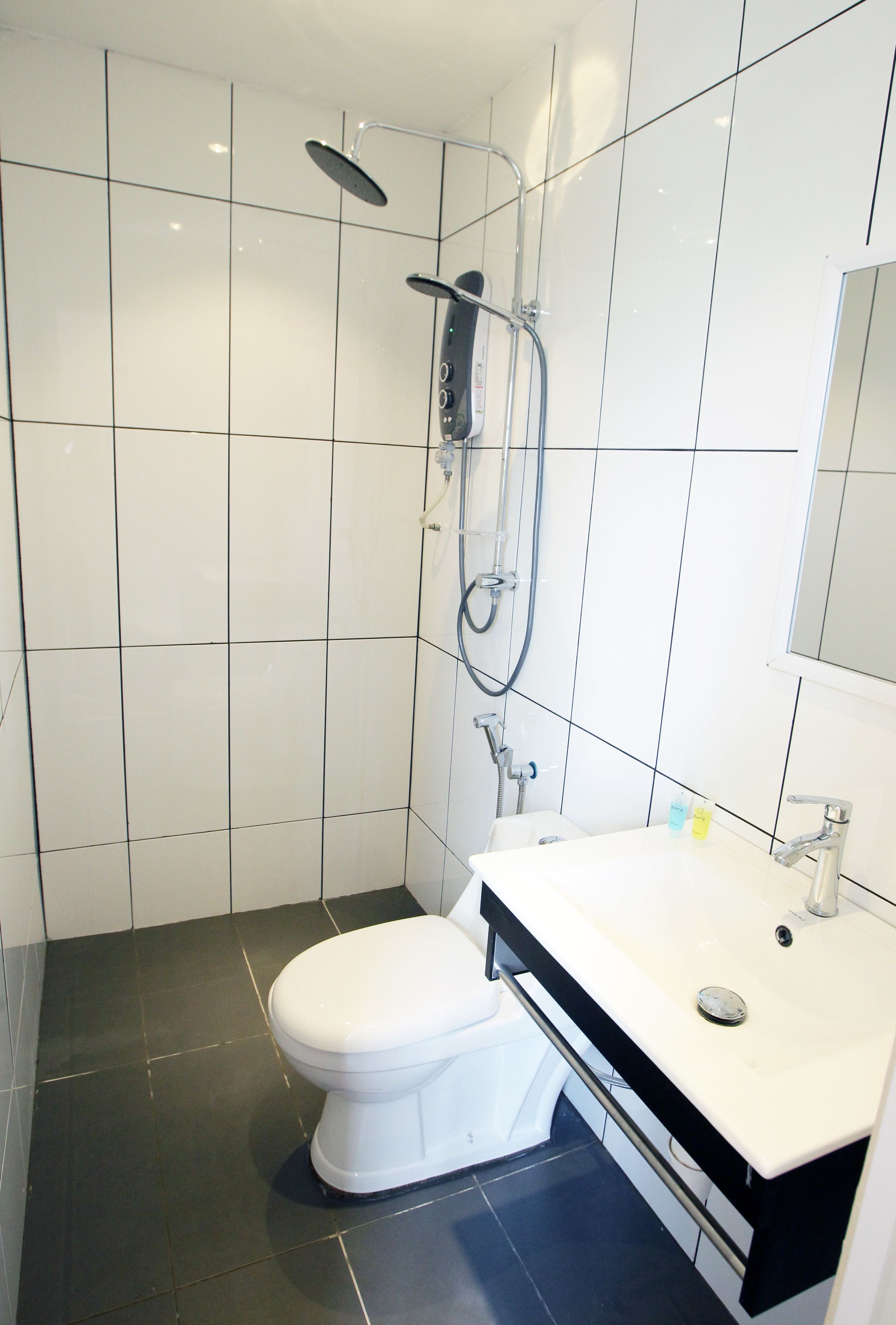 A modern bathroom with a toilet, a sink, and a shower.