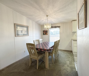 A dining room with a table and chairs, a chandelier, and framed pictures on the walls. - 3 Bedroom Palm Key Village Home - PK015 (Davenport)