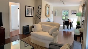 A living room with a sofa, a coffee table, and a dining area with a table and chairs.