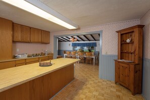 Una cocina con armarios de madera, una isla grande y una zona de comedor con sillas y una mesa.