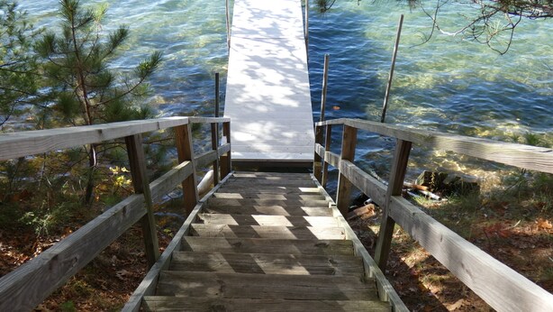A wooden staircase leading to a dock over water.