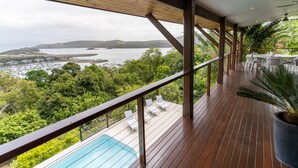 A wooden deck with a pool, overlooking a bay with boats and greenery. - Cowries - Hamilton Island (Hamilton Island)