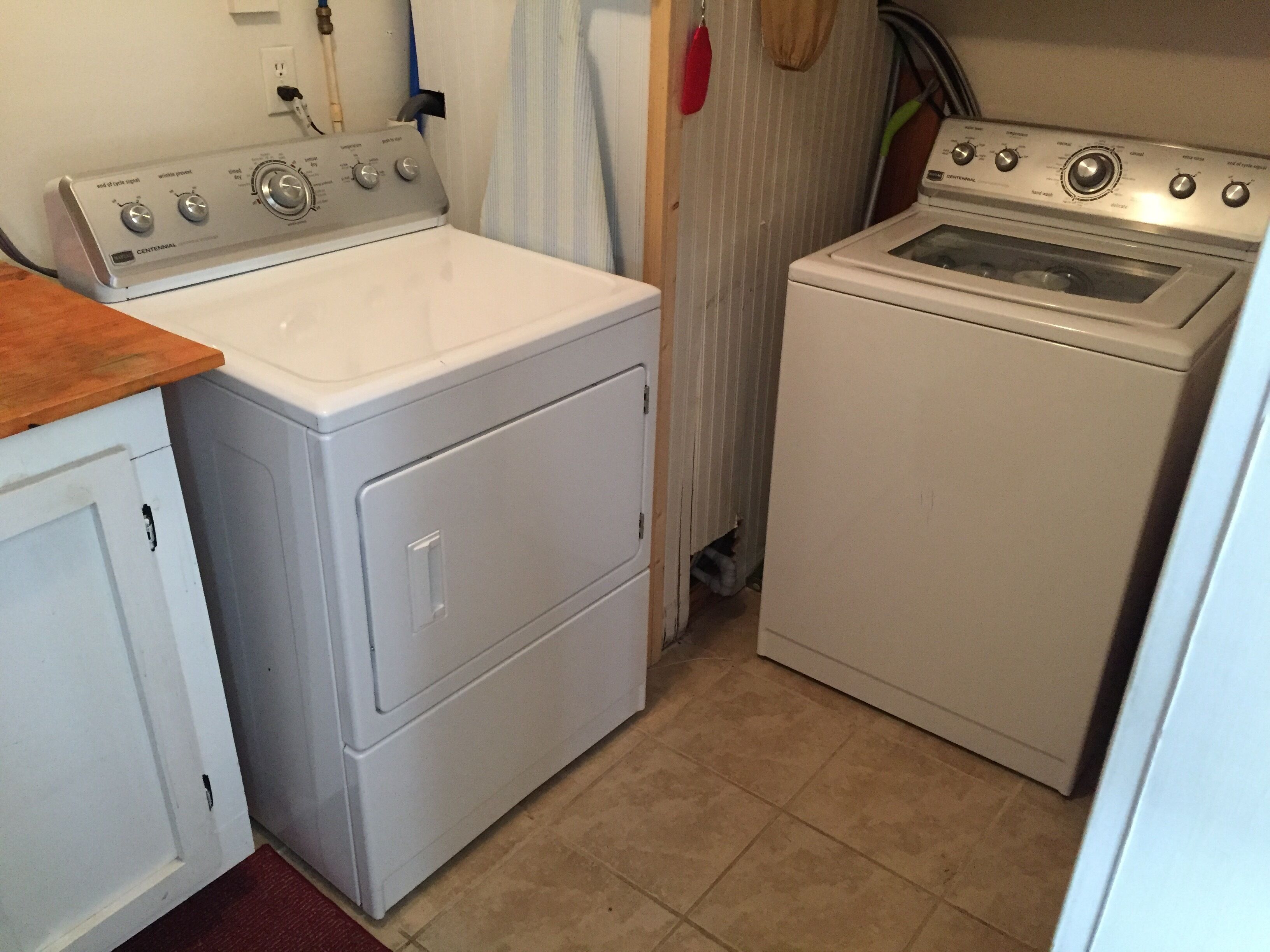 A laundry room with a front-loading washer and a top-loading dryer.