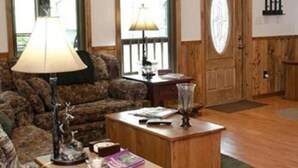 Ein gemütliches Wohnzimmer mit einem gemusterten Sofa, einem Couchtisch und einer Lampe.