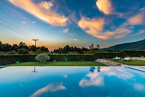 A swimming pool with a clear view of the sky and surrounding greenery.