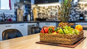 A kitchen with a fruit basket on the table.