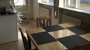 A kitchen with a dining table, chairs, and a view of a lake and mountains. - Nice Holiday Apartment, Centrally Located With Spectacular Sea And Mountain View (Akureyri)
