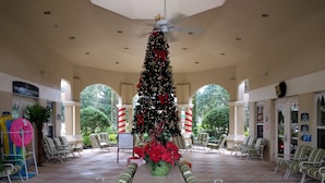 Ruime binnenruimte met een kerstboom in het midden, zitgedeeltes en een bord met 'The Marketplace & Grill'.