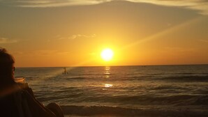 A sunset over the ocean with a person in the foreground. - Beautiful Naples Condo (Naples)
