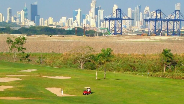 Un parcours de golf avec la silhouette de la ville en arrière-plan.