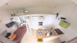 A compact living space with a kitchen, dining area, and a small seating area. - Bungalow by The Sea (Trondheim)