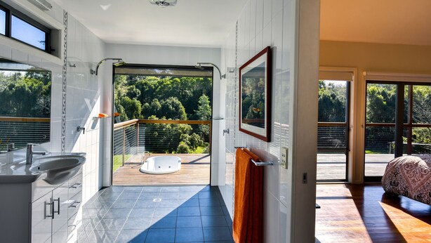 Une salle de bain moderne dotée d’une grande fenêtre, d’une douche et d’une baignoire.