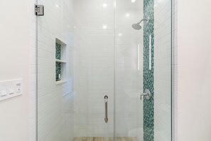 Bathtub, rainfall showerhead, hair dryer, towels