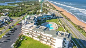 A beachfront hotel with a swimming pool, multiple balconies, and a view of the ocean. - Remodeled! - Direct Walk Out to Beach & Pool - Pet Friendly  (Flagler Beach)