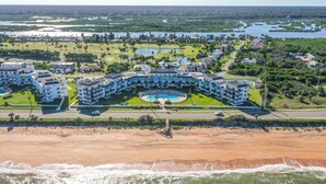 A resort with a central pool, beachfront, and multiple buildings. - Remodeled! - Direct Walk Out to Beach & Pool - Pet Friendly  (Flagler Beach)
