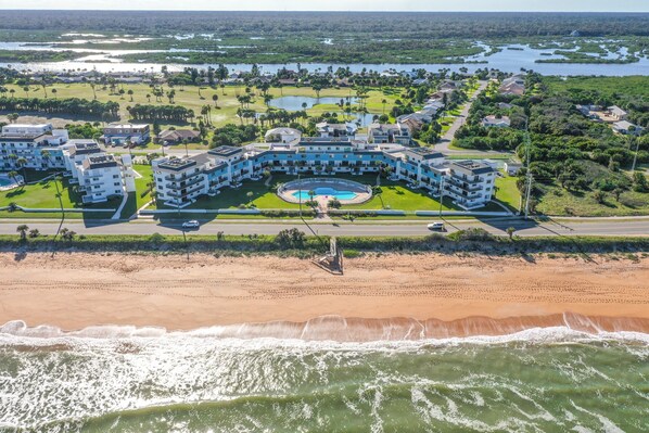 A resort with a central pool, beachfront, and multiple buildings. - Remodeled! - Direct Walk Out to Beach & Pool - Pet Friendly (Flagler Beach)