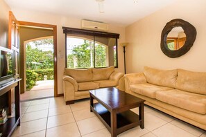 A living room with two sofas, a coffee table, and a television. - Cozy Ground-Floor Condo w/ Community Pool, Rancho & Lush Garden Views (Santa Cruz)