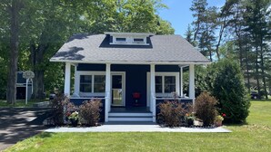 A two-story house with a porch, a garage, and a basketball hoop in the driveway. - Walloon Lake Cottage; Minutes Walk to Water & The Village (Walloon Lake)