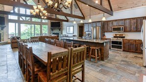 A spacious kitchen with a large island, wooden cabinetry, and modern appliances.