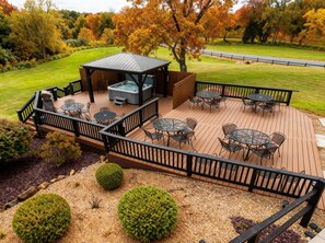 Une terrasse avec coin salon extérieur, un jacuzzi et un espace abrité.