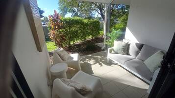 Un patio abrité comprenant un canapé, deux fauteuils et une petite table.