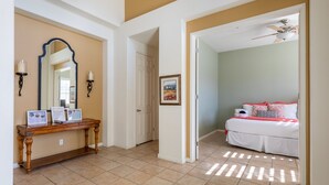 A hotel room with a bed, a desk with a computer, and a bathroom visible through an open door. - Ideal Summer getaway home  License #065778 (La Quinta)