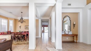 A spacious living room with a dining area, a large mirror, and a chandelier. - Ideal Summer getaway home  License #065778 (La Quinta)