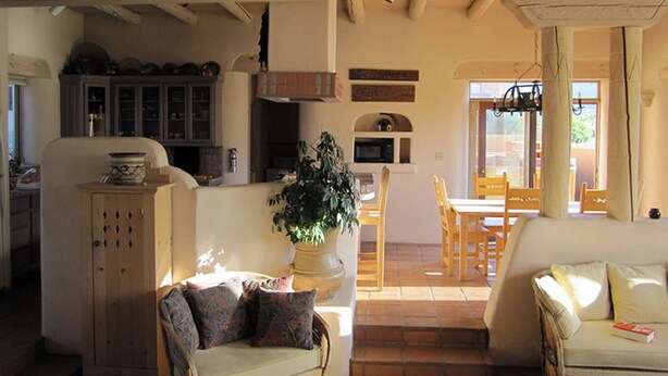 Un espacio acogedor con sofá, una mesa de comedor y una cocina al fondo.